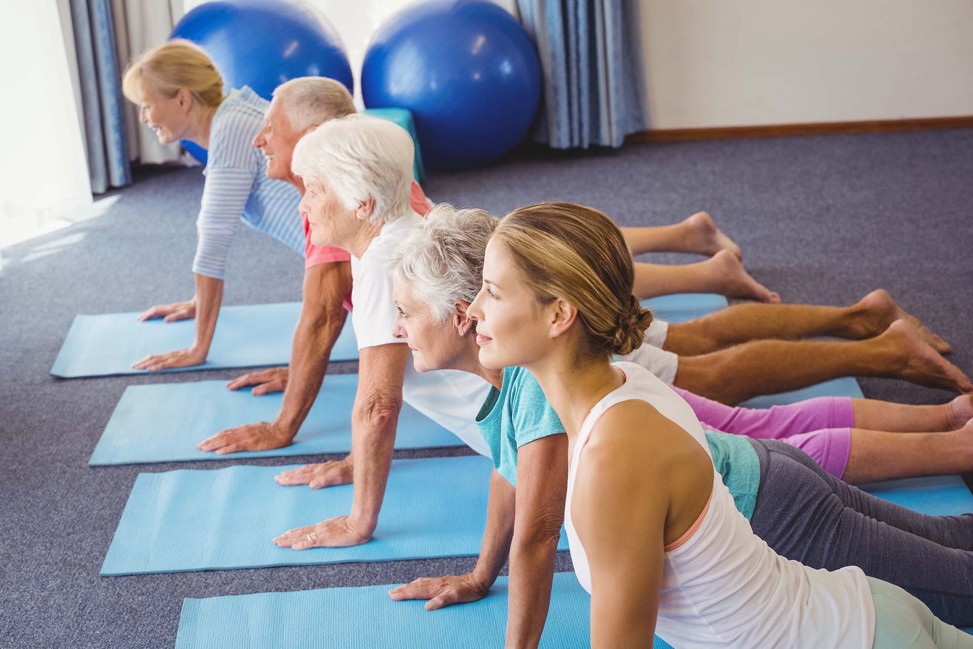 Groupe pratiquant le Pilates au sol